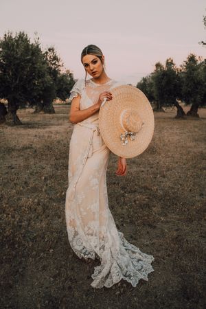 Woman in dress holding hat