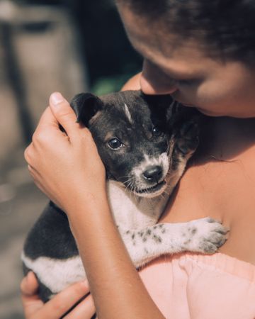 Woman holding short coated puppy