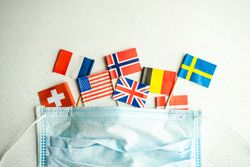 COVID-19 concept  with face mask and mini flags of countries