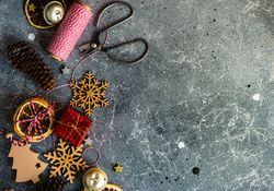 Christmas ornaments and scissors and string on marble table