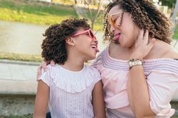 Hispanic Mother and daughter in the park, playing and laughing