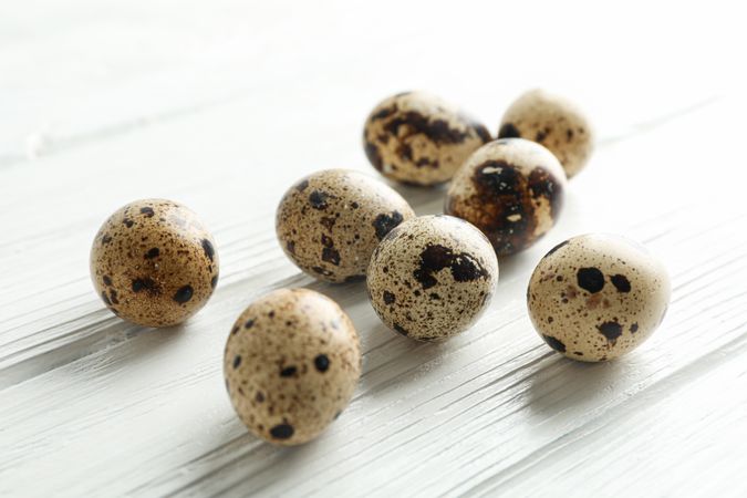 Quail eggs on wooden background, space for text and closeup