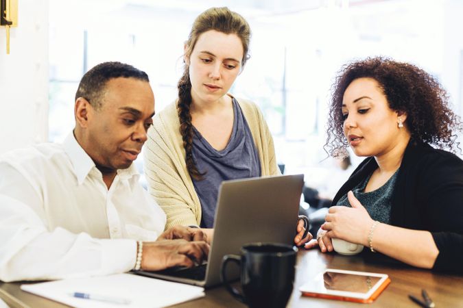 Three employees discussing work a business meeting