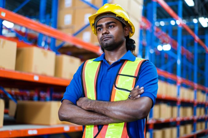 Serious employee at the factory standing with arms crossed