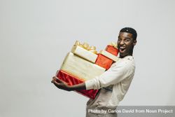 Excited Black man holding a stack of wrapped presents 5z2om5