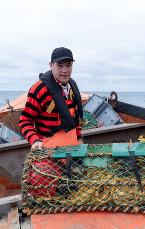 Young fisherman looking at camera ready to work