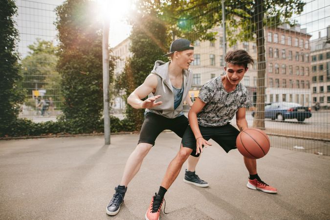 Two men playing basketball on outdoor court