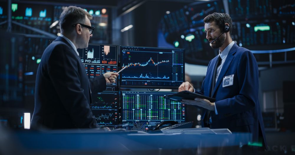 Two Successful Traders Analyzing Real-Time Financial Data and Reports About the State of the Finance Market.