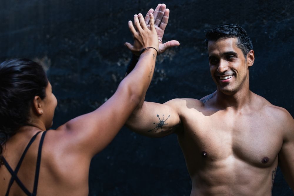 Sportive Hispanic couple giving high five