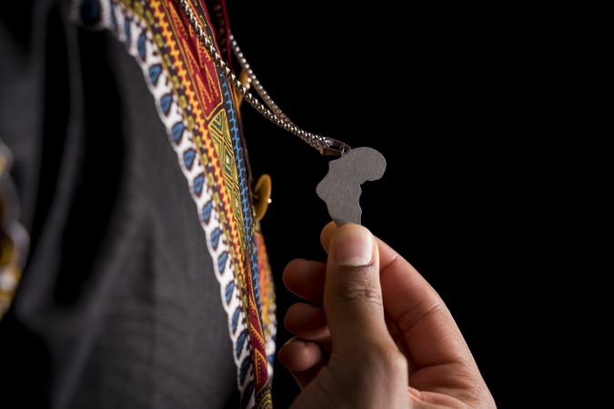 Silver chain on neck and pendant depicting Africa in hands