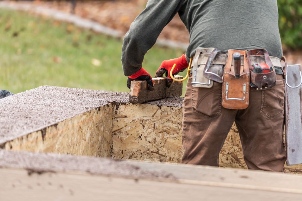 Construction Worker Leveling Wet Cement Into Wood Framing