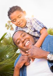 Son and Father Playing Piggyback Outdoors Together.