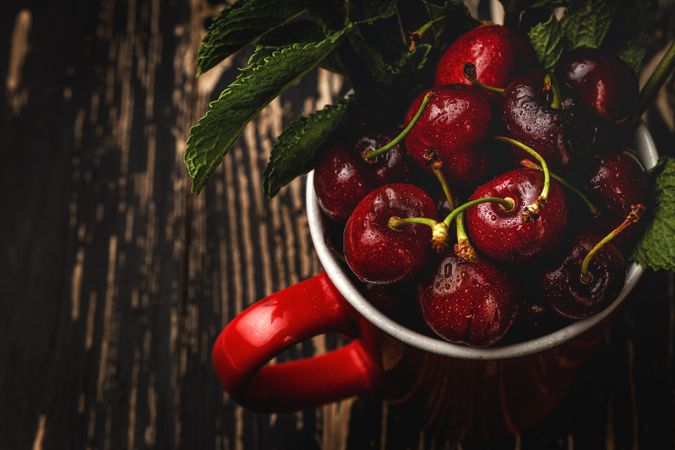 Cherry with branches in cup on table