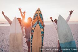 Group of young women with surf boards at the beach n56xdb