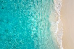 Aerial shot of beautiful clear blue water coming up on a beach