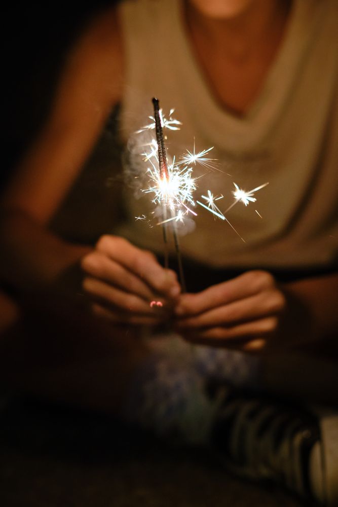 Crop person with burning Bengal lights