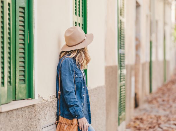 Woman leaning on stone house