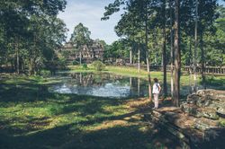 Female traveler in garden near temple