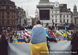 London, England, United Kingdom - March 5 2022: Woman at protest wrapped in Ukrainian flag blanket 5RAZA0