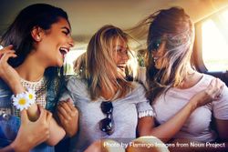 Group of female friends happily riding in back of vehicle 5zqWn0