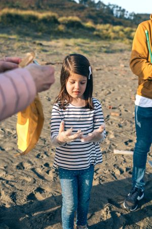 Girl and volunteers preparing to clean the beach