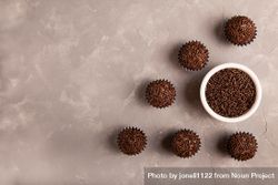 Top view of chocolate truffles with sprinkles on marble surface with space for text 5wx1L4