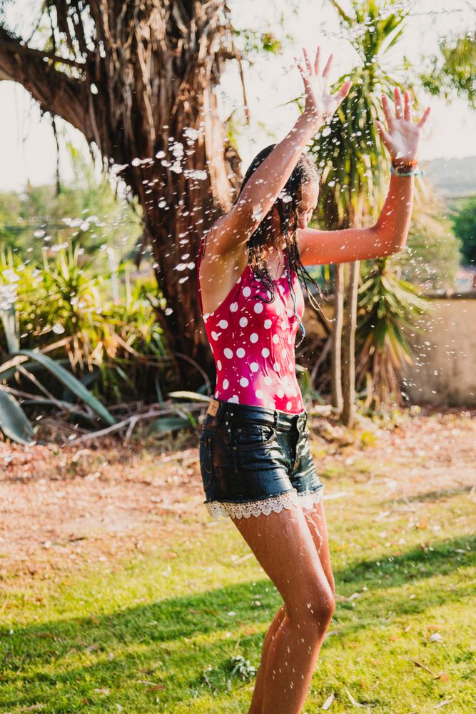 Cheerful teenager having fun with jet of water