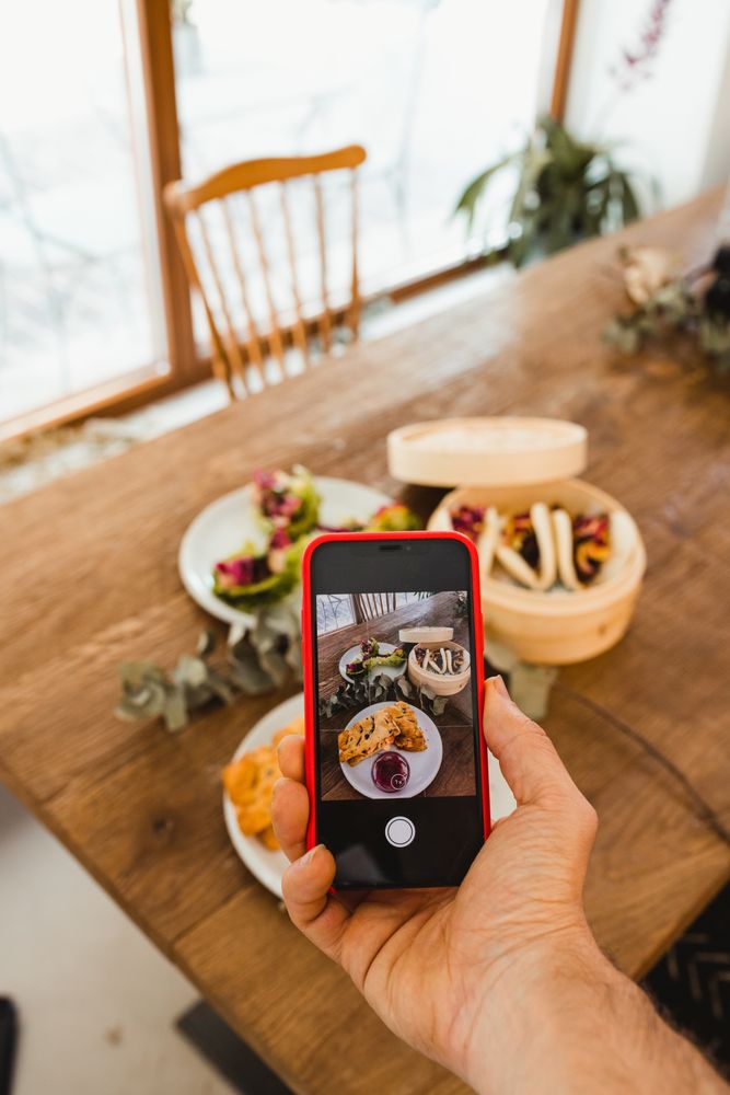 Photographer taking picture of food with smartphone