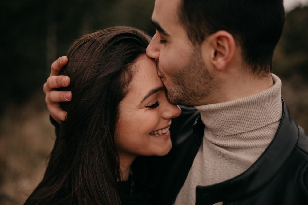 Happy couple hugging among pine forest