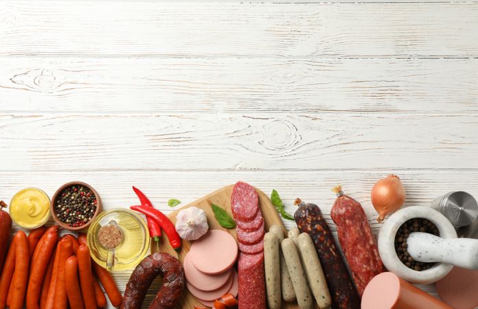 Selection of cured meats with copy space on wooden background