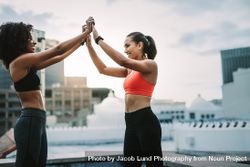 Happy fitness women giving high five after their workout on rooftop 4ZBR34