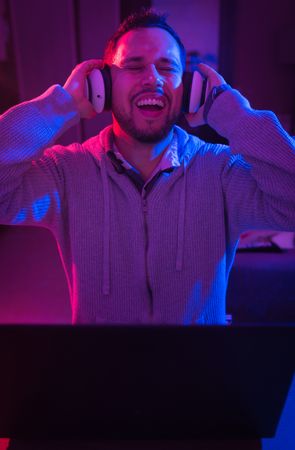Man listening cheerfully to music with headphones.