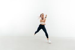 Sporty woman running forward indoors