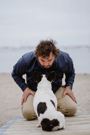 Man and dog resting on beach together