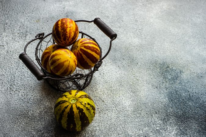 Organic mini melons in wire fruit basket
