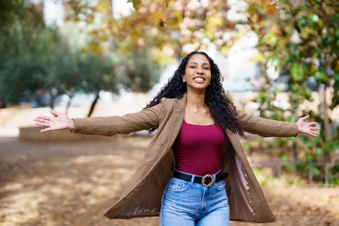A Joyful Woman Embracing Nature in a Beautiful Park Setting Among the First Signs of Autumn