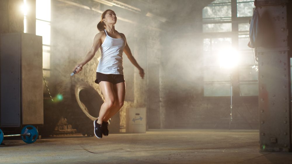Athletic Woman Exercises with Jump   Skipping Rope in a Gym.