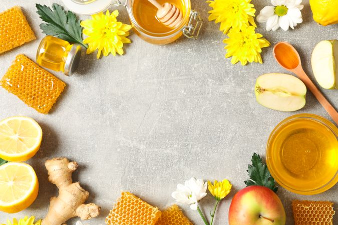 Flat lay with honey, flowers and fruits on grey background, copy space