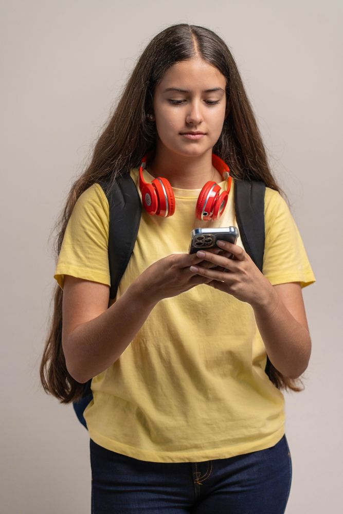 A young student using her smartphone, texting or Browse social media.