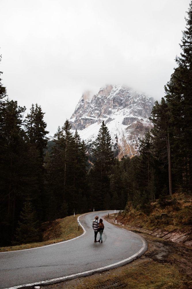 Casual resting couple standing in an embrace on route amid forest