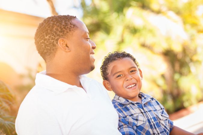 Black Son Laughing With Father Outdoors