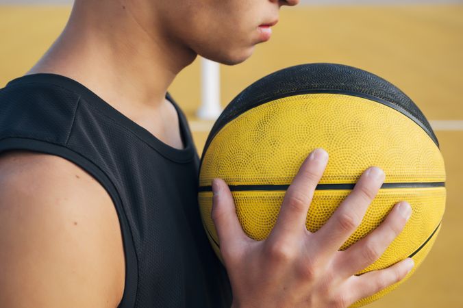 crop Young man and ball playing on basketball court outdoor.