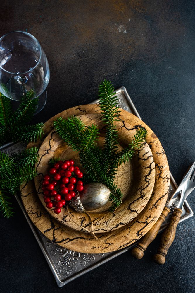Top view of rustic plates, cutlery and glass with xmas pine and ornament