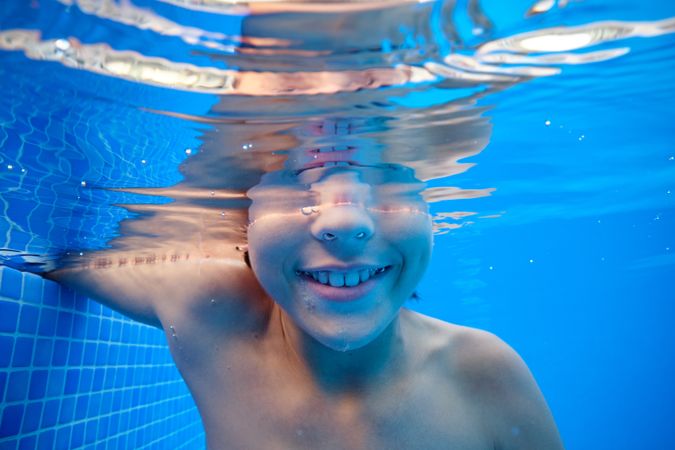 Positive boy in clean swimming pool