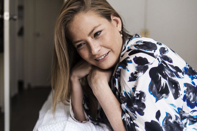 Woman in floral robe smiling at home