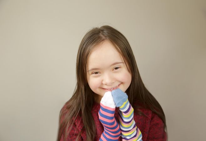 Young girl smiling and playing with socks on her hands