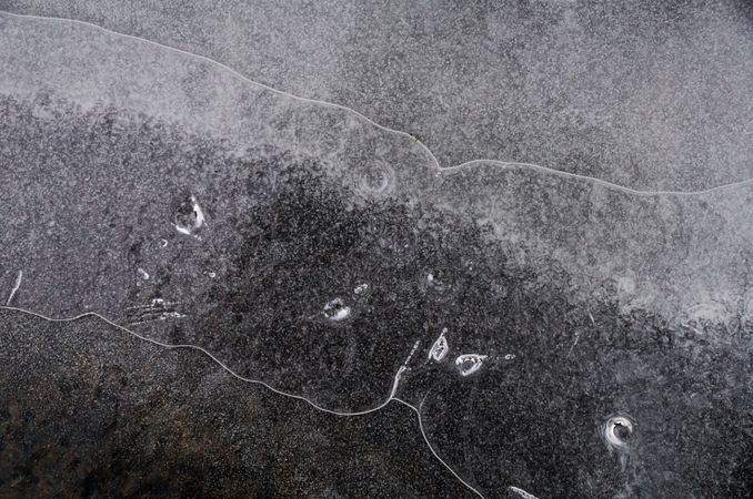 Fragment of thin ice on dark frozen river