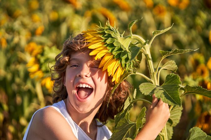 Excited boy putting blooming flower on head