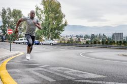 Healthy male jogging on city street