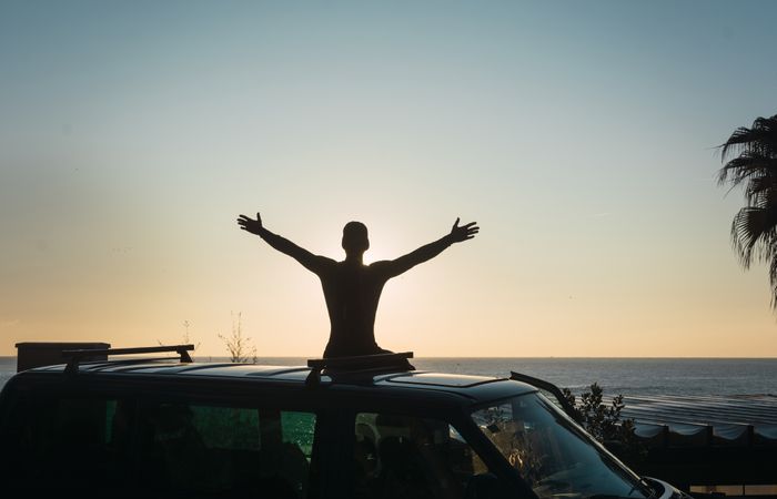 Man enjoying the sunrise in his camped van